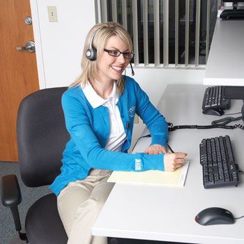 Happy woman sitting at work on a computer.